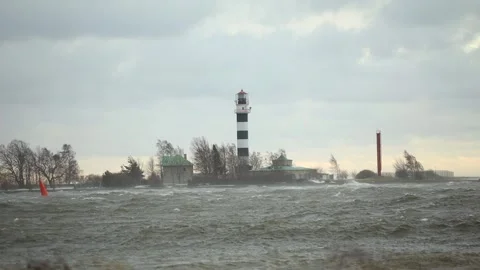 Black and White Lighthouse on Windy Coastal Day with Red Tower Stock Footage 296512076