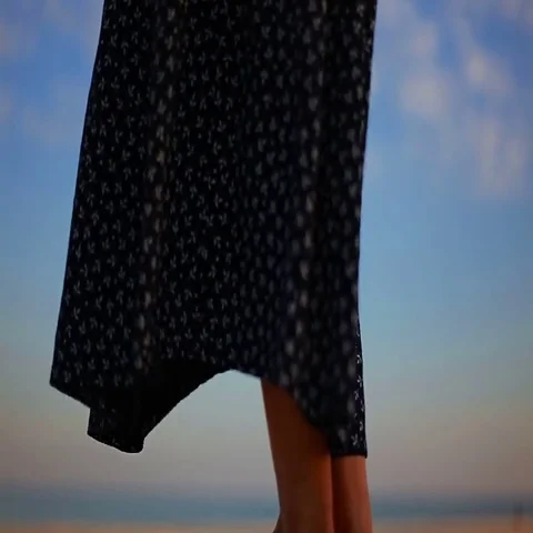 Black and white patterned female skirt fluttering in the wind on the sea shore Stock Footage 69464873
