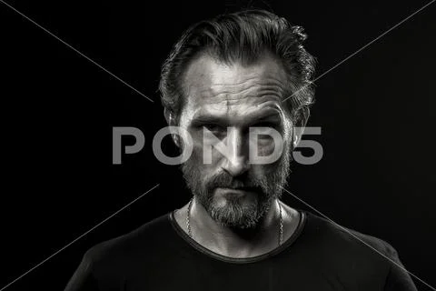 Black and white photo of mid aged man showing severe emotion. Stock Photos