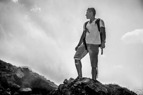 Black and white photo of travel man standing on the rock on the cloud Stock Photos
