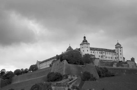 A black and white photograph of a castle on a hill. Stock Photos