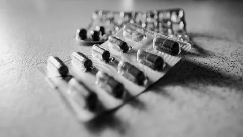 Black and White Pills Scene with Shifting Sunset Shadows - Slow Cinematic Zoom Stock Footage 306587540