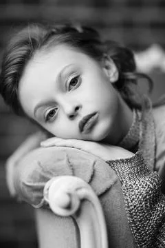 Black-and-white portrait of a cute eight-year-old girl, calmly and thoughtful Stock Photos