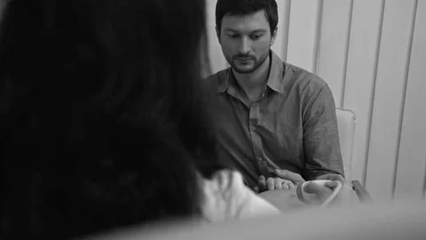 Black and white shot of a professional doctor performing ultrasound scanning for Stock Footage