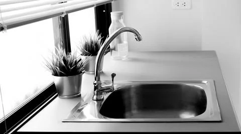 Black and white sink in modern renovated home kitchen with silver faucet. Hou Stock Photos