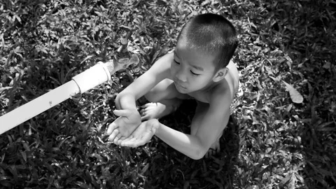 Black and white slow motion of Young asian boy waiting for water Stock Footage 73373993