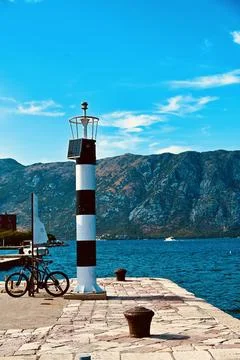 Black and White Striped Lighthouse on Stone Pier Stock Photos