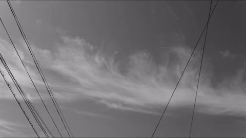 Black and white time lapse cirrus clouds rolling over power lines Видео 342451160