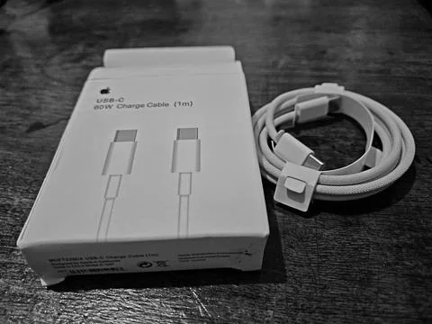 Black and white of a USB-C charge cable (1m) on a wooden table Stock Photos