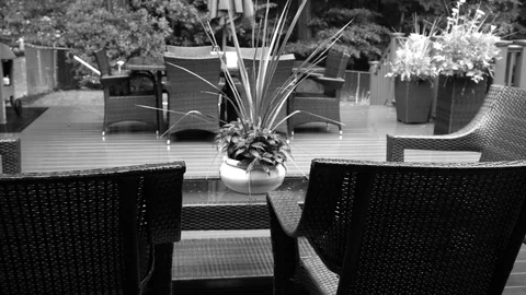 Black and White video of Rain lightly pattering on a suburban deck during Stock Footage 118600076