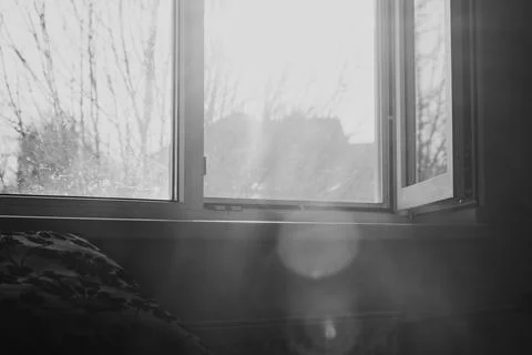 Black and white view of an open window with bright light and smoke effects Stock Photos