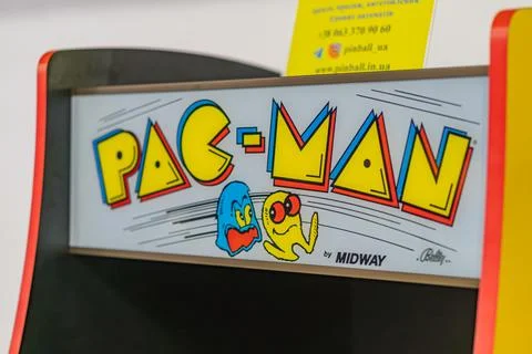 Black arcade machine with Pac-Man graphics, featuring Pac-Man and Blinky in.. Stock Photos