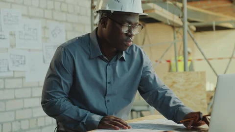 Black Architect Working on Floor Plan and Using Laptop at Construction Site Vídeos de archivo 273460616