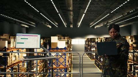 Black army soldier coordinating tactical planning in warehouse Stock Photos