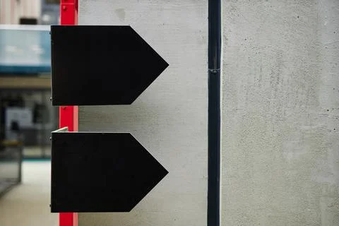 Black Arrows as Minimalist Design Elements on Concrete Wall in Business Center Stock Photos