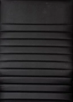 Black artificial leather background, textured surface material close-up. Stock Photos