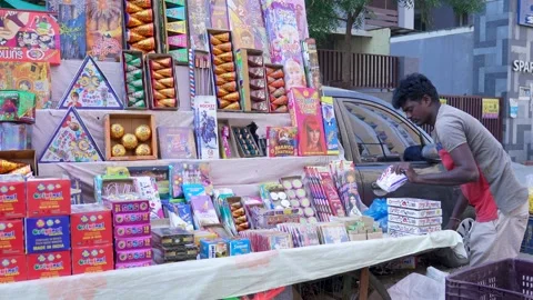 Black Asian Guy working hard at street shop - Diwali Crackers Selling in India Stock Footage 220074113