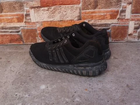 Black Athletic Mesh Sneakers on Rustic Stone Background Stock Photos