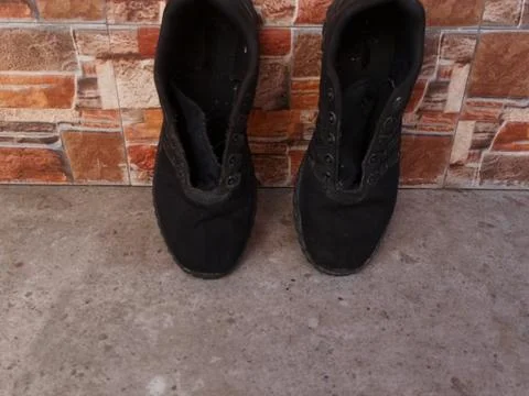 Black Athletic Mesh Sneakers on Rustic Stone Background Stock Photos