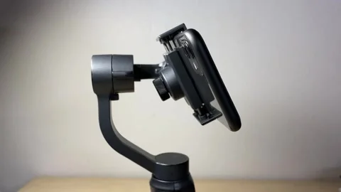 Black automatic gimbal stabilizer holding black phone indoor Video stock 250452622