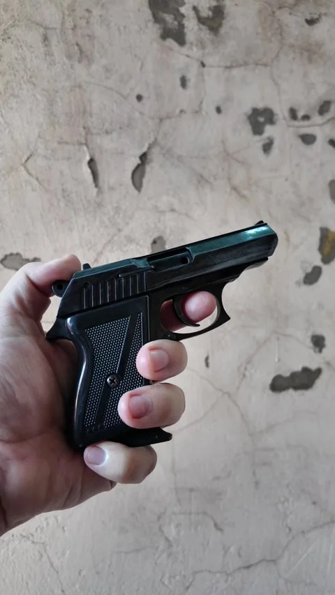 Black automatic pistol in hand. Man shoots from pistol. Concept weapon. Old.. Stock Footage 314383140