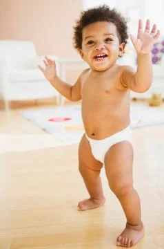 Black baby girl learning to walk Stock Photos
