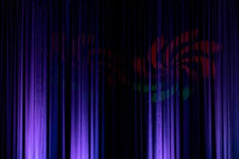 Black backdrop with blue lights with a red and green hieroglyph in the middle Stock Photos