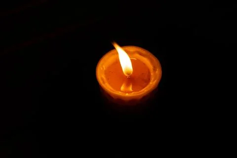 On a black background, a burning candle Fotos Stock