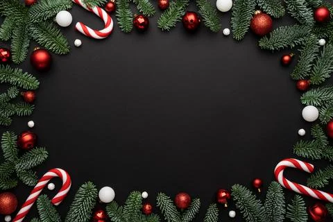 Black background with Christmas decorations of fir branches and Christmas bal Stock Photos
