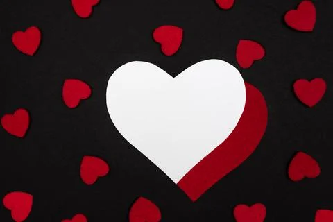 Black background decorated with small red hearts Stock Photos