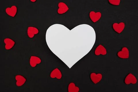 Black background decorated with small red hearts Stock Photos
