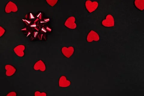 Black background decorated with small red hearts Foto stock