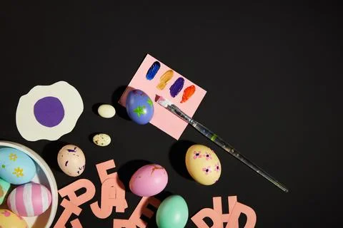 Black background featured Easter eggs painted with different patterns and col 库存照片