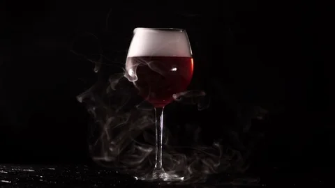 On a black background with glasses of red liquid coming out steam Stock Footage 72098479
