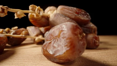 With a black background, I gently pick up a dried date on a branch from the tabl Stock Footage 244864364