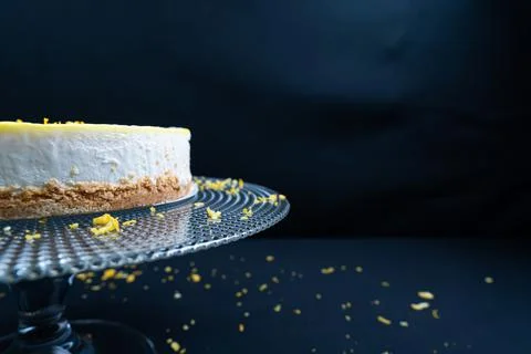 Black background, Lemon cheese cake on a glass plate. Stock Photos