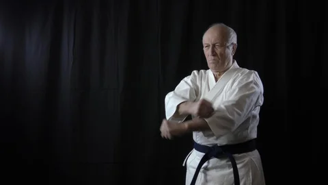On a black background, an old man athlete beats punches Stock Footage 127942699