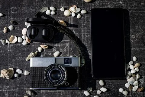 On a black background, a set of tourists: camera, mobile phone, headphones Stock Photos