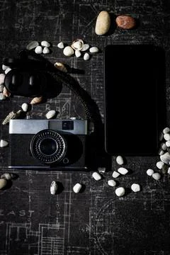 On a black background, a set of tourists: camera, mobile phone, headphones Stock Photos