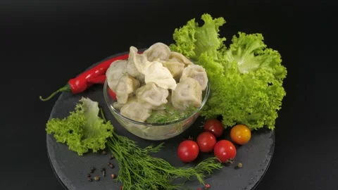 On a black background on a stone tray dish of dumplings with meat. Video stock 163764965
