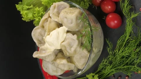 On a black background on a stone tray dish of dumplings with meat. Video stock 234009346