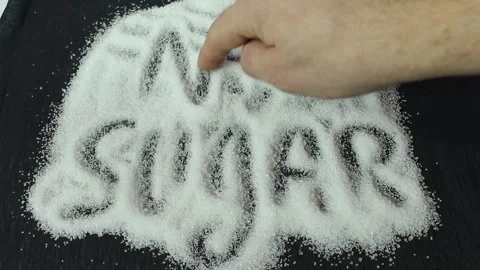 On a black background is sugar labeled “no sugar”. A green apple is rolling Stock Footage 300488632
