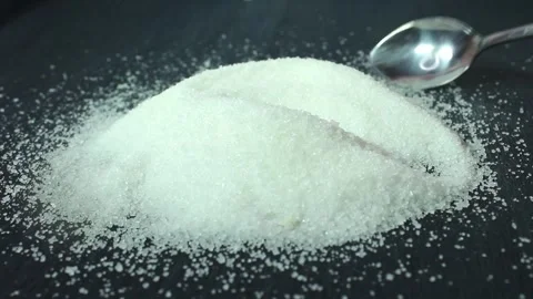 On a black background is sugar labeled “no sugar”. A green apple is rolling Stock Footage 300488743