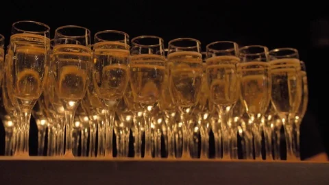 Black background.Table with champagne glasses,with bubbles coming from bottom. Stock Footage 106001066