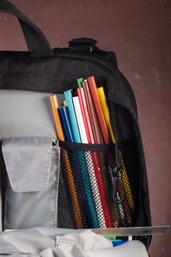 Black backpack with skolkimi items, back to school Foto stock