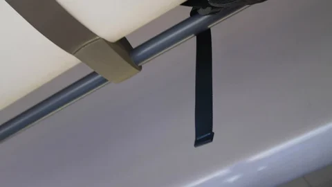Black backpack strap hanging from the top shelf in a moving bus Stock Footage 112282097