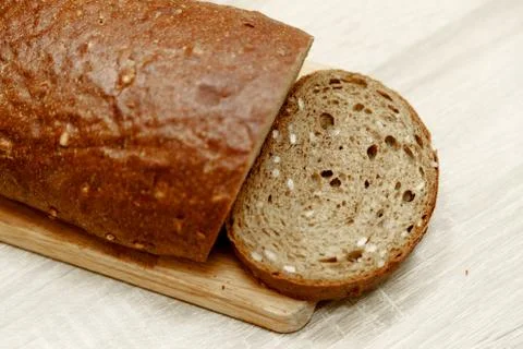 Black baked bread and one sliced piece Stock Photos