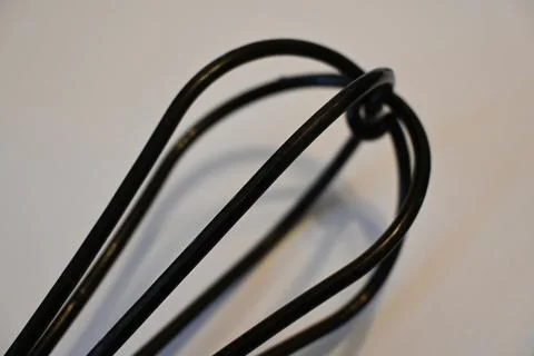 Black balloon whisk on a light surface 库存照片