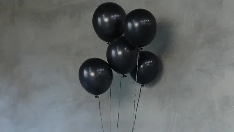 Black Balloons Against Gray Wall Stock Footage 95967633
