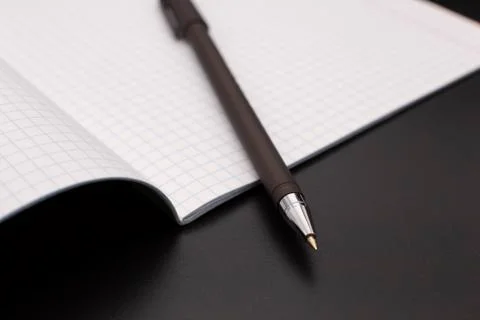 A black ballpoint pen is lying on the notebook Fotos de archivo